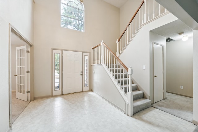 carpeted entryway with a high ceiling