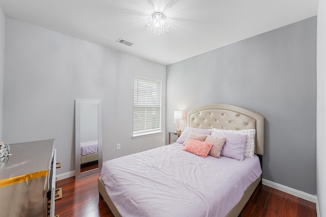 bedroom with a chandelier and dark hardwood / wood-style flooring