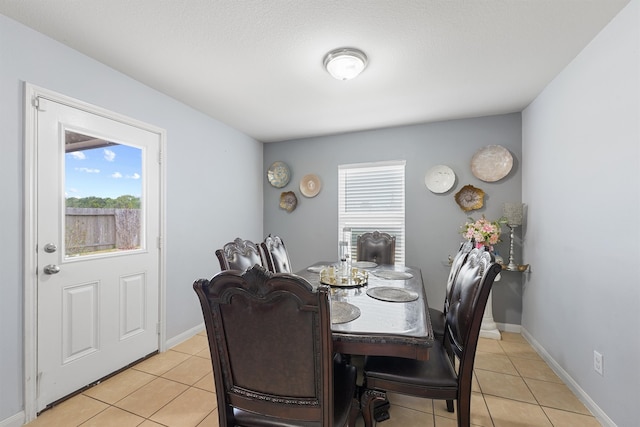 tiled dining area featuring a textured ceiling