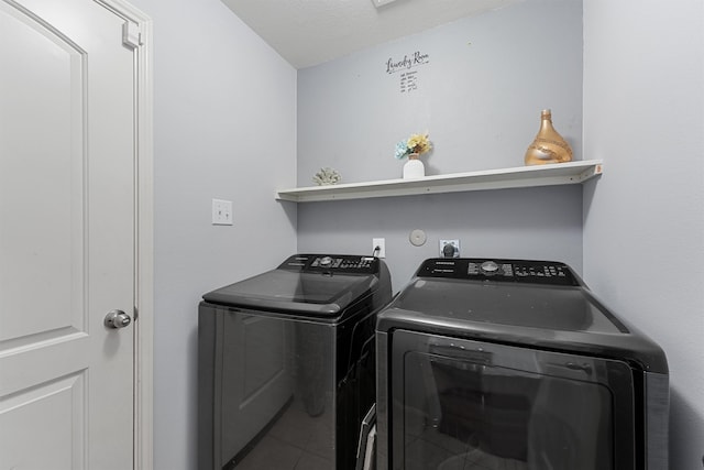 laundry area with a textured ceiling and separate washer and dryer