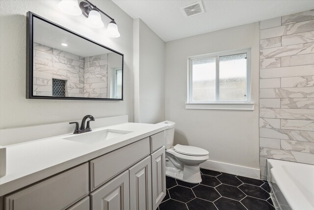 full bathroom featuring vanity, toilet, tiled shower / bath combo, and tile patterned floors