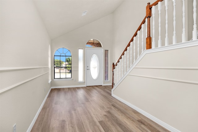 entrance foyer featuring high vaulted ceiling and light hardwood / wood-style flooring