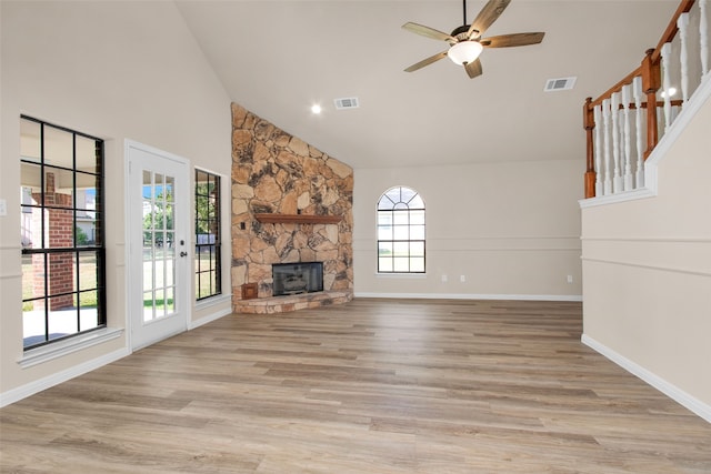 unfurnished living room with plenty of natural light, high vaulted ceiling, and light hardwood / wood-style flooring