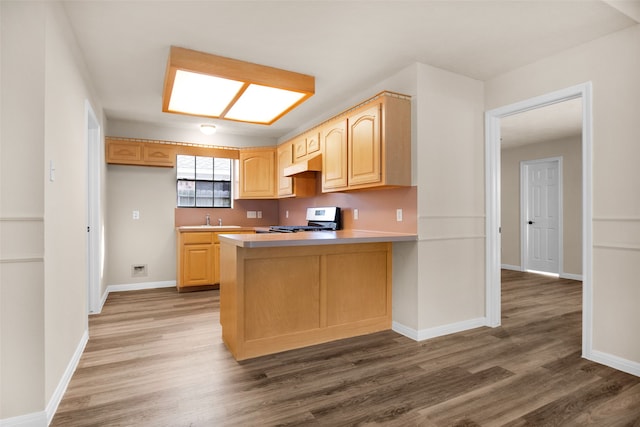 kitchen with white range oven, sink, dark hardwood / wood-style flooring, and light brown cabinets