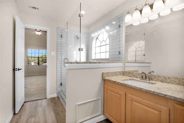 bathroom featuring vanity, hardwood / wood-style flooring, ceiling fan, and a shower with shower door