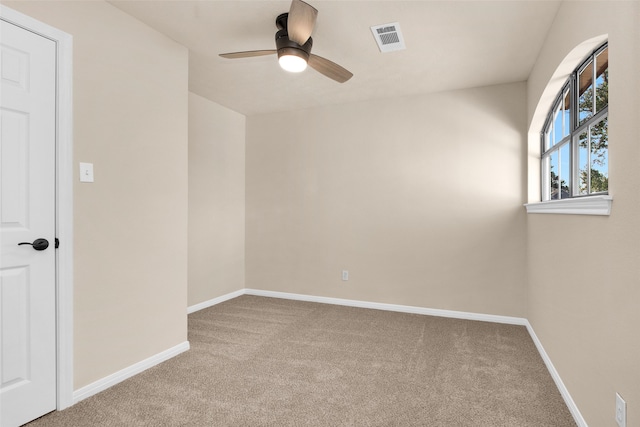 carpeted spare room featuring ceiling fan