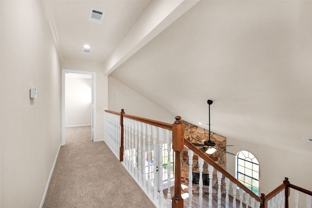 corridor featuring light colored carpet, a wealth of natural light, and vaulted ceiling