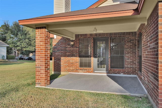 doorway to property with a yard, a patio, and ceiling fan