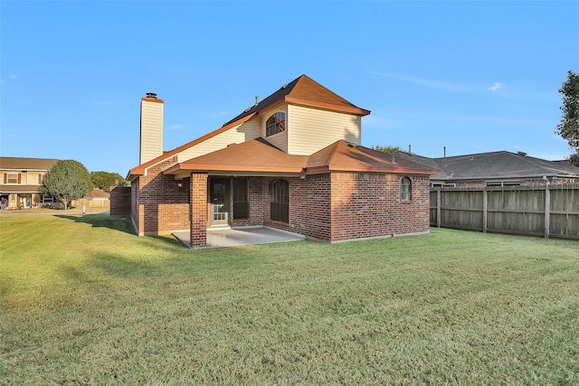 rear view of property featuring a patio area and a lawn