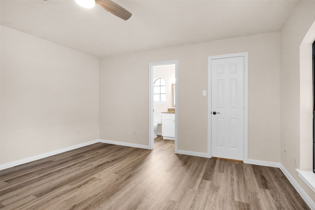 unfurnished bedroom with ceiling fan, a closet, light hardwood / wood-style flooring, and ensuite bath