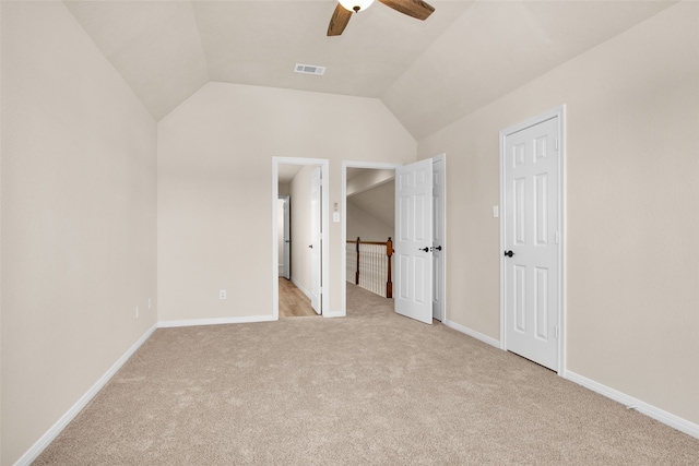 unfurnished bedroom featuring light carpet, ceiling fan, and vaulted ceiling