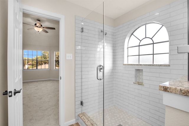 bathroom with ceiling fan and a shower with door