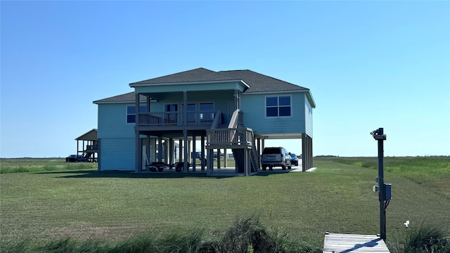 rear view of house with a lawn and a carport