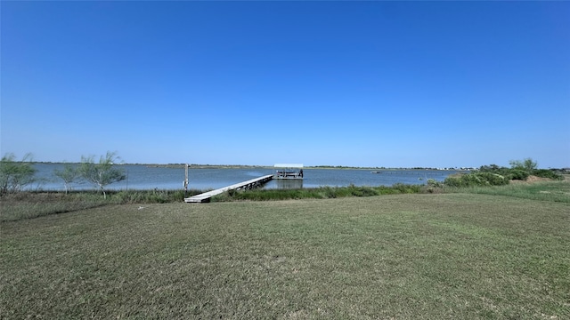 view of dock with a water view and a lawn