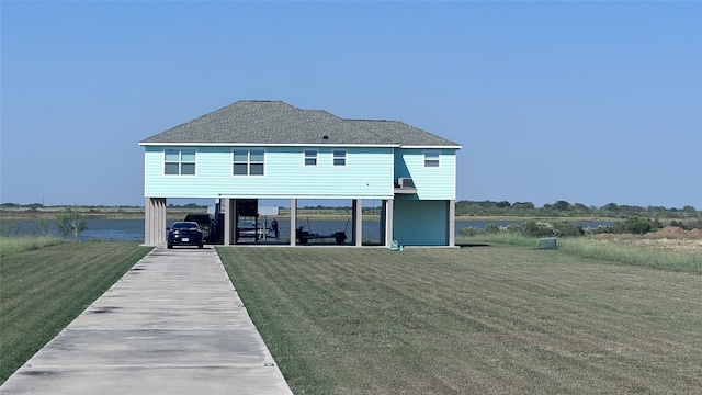 rear view of house with a lawn and a water view