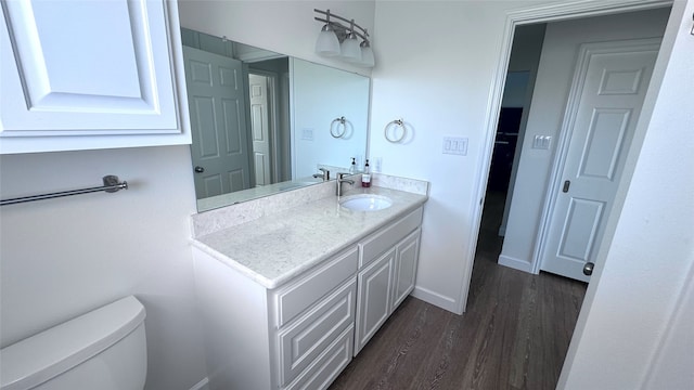 bathroom featuring toilet, vanity, and wood-type flooring