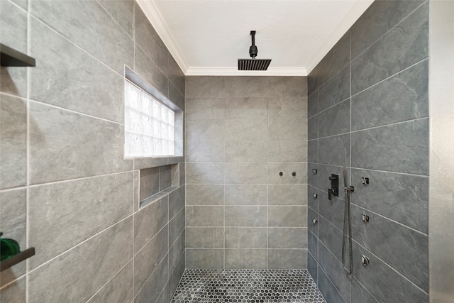 bathroom featuring a tile shower and crown molding