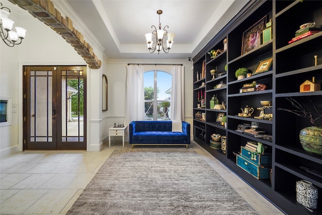 sitting room featuring a chandelier, light tile patterned flooring, french doors, and a raised ceiling