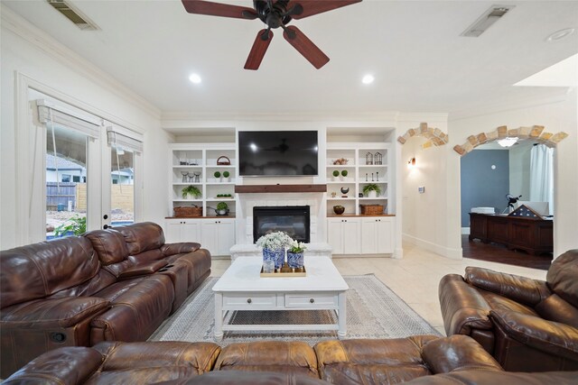 tiled living room with french doors, ornamental molding, and ceiling fan