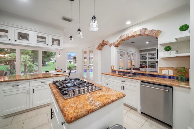 kitchen with light tile patterned flooring, a center island, white cabinets, and stainless steel appliances