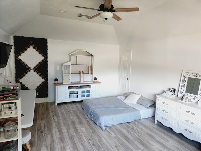 bedroom featuring light hardwood / wood-style floors, ceiling fan, and vaulted ceiling