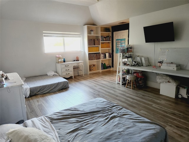 bedroom featuring hardwood / wood-style floors and vaulted ceiling