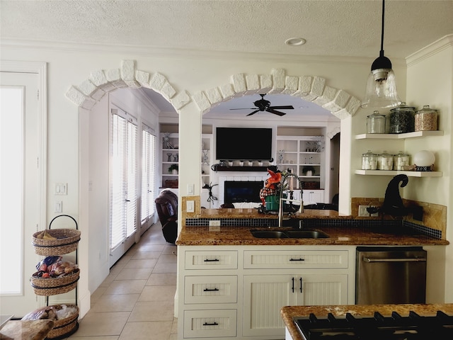 kitchen with sink, ceiling fan, a textured ceiling, and light tile patterned floors