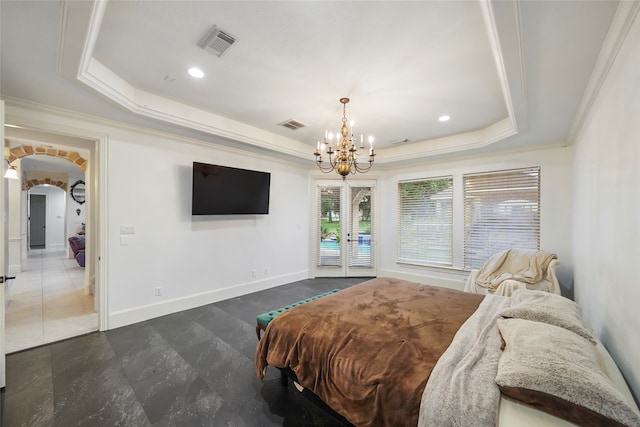 bedroom featuring french doors, crown molding, a tray ceiling, and a chandelier