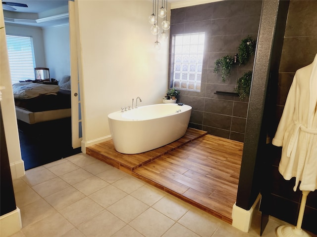 bathroom featuring a tub to relax in, ornamental molding, and tile patterned flooring