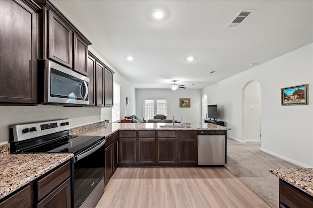 kitchen featuring kitchen peninsula, ceiling fan, light hardwood / wood-style flooring, sink, and stainless steel appliances