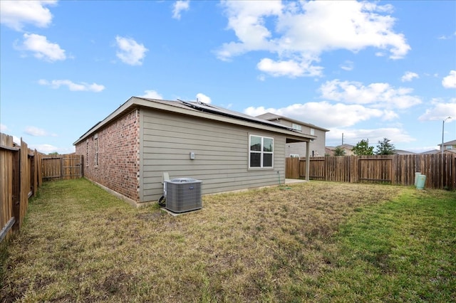 rear view of house with cooling unit and a lawn