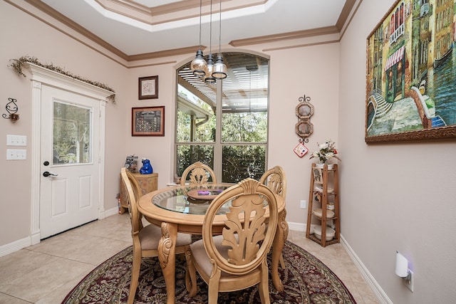 tiled dining area featuring a raised ceiling, crown molding, and an inviting chandelier