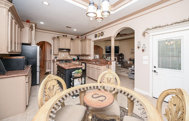 tiled dining area featuring a notable chandelier, ornamental molding, and sink