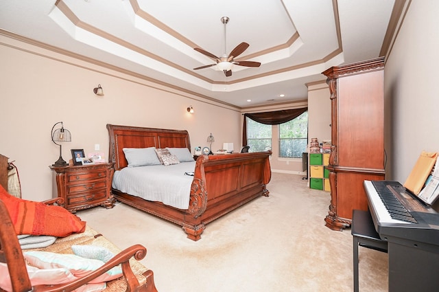 carpeted bedroom featuring ceiling fan, a raised ceiling, and ornamental molding