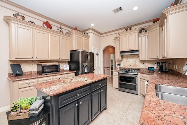 kitchen featuring cream cabinetry, stainless steel appliances, and tasteful backsplash