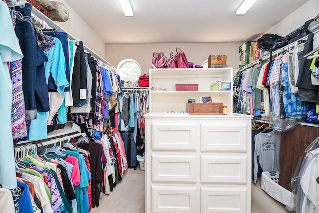 walk in closet featuring light colored carpet