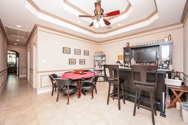 dining area featuring a raised ceiling, ceiling fan, and ornamental molding