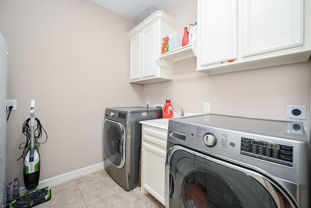 laundry area featuring cabinets, washer and clothes dryer, and light tile patterned flooring