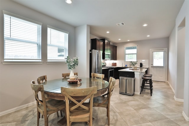 dining room featuring sink and light tile patterned floors