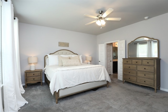 bedroom featuring dark carpet, connected bathroom, and ceiling fan