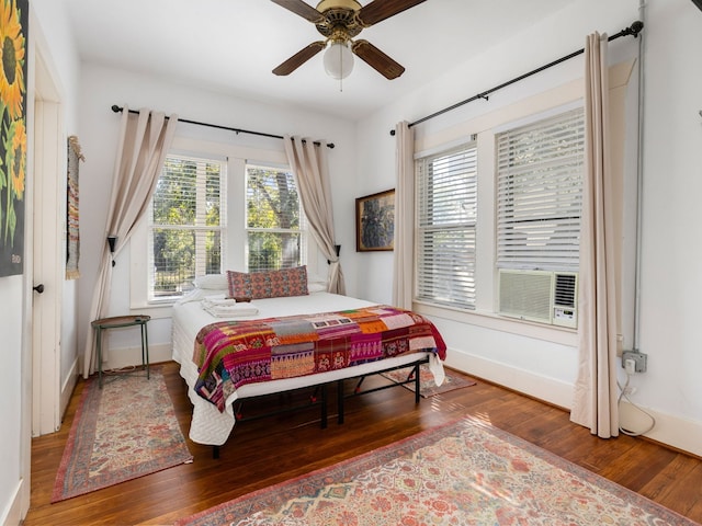 bedroom with cooling unit, hardwood / wood-style flooring, and ceiling fan