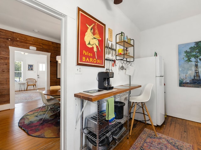 office with ceiling fan, wood walls, wood-type flooring, and crown molding