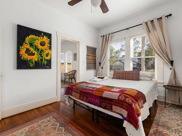 bedroom with dark hardwood / wood-style floors and ceiling fan