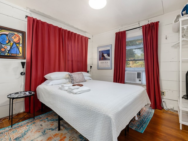 bedroom featuring wood walls and hardwood / wood-style floors