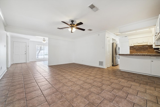 unfurnished living room with crown molding, light tile patterned flooring, and ceiling fan