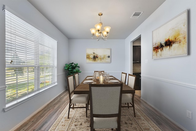 dining area with dark hardwood / wood-style flooring and a notable chandelier