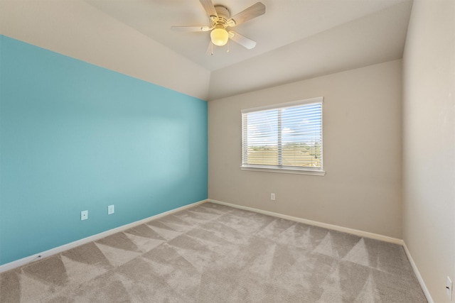 spare room featuring ceiling fan, light colored carpet, and lofted ceiling