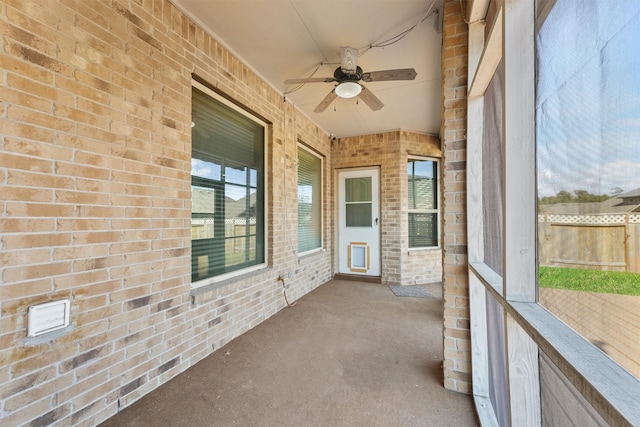 unfurnished sunroom with ceiling fan