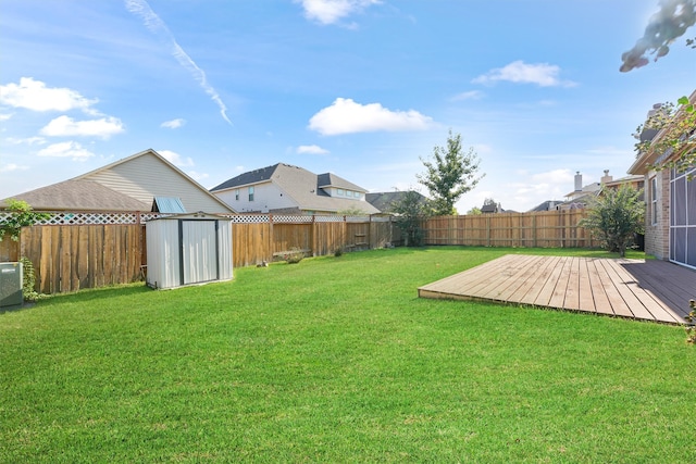 view of yard featuring a storage unit and a wooden deck