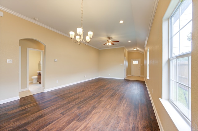 empty room with ceiling fan with notable chandelier, a healthy amount of sunlight, dark hardwood / wood-style flooring, and ornamental molding